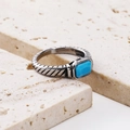 Macro detail of vintage 18k gold ring with blue square gemstone and textured metal - Steel Turquoise Zirconia