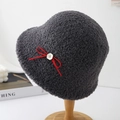 Detail view of a grey fuzzy sherpa bucket hat with a red bow and button accent - Gray