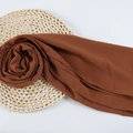 Lightweight rust red chiffon headscarf with natural drape on woven straw mat - 84