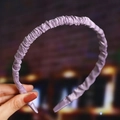 Close-up of a purple satin-wrapped wavy headband held by hand with high-quality texture - Purple (Satin)