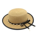 Dettaglio cappello di paglia con nastro nero, perle bianche ed elegante fiocco - Cachi