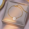 Golden stainless steel thin chain bracelet featuring a white five-petal flower pendant - Bracelet / Gold