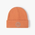 Orange ribbed knit beanie featuring a grey embroidered smiley face and folded cuff - One Size / Orange Red