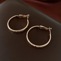 Gros plan de boucles d'oreilles créoles dorées texturées avec finition mate étincelante - Style Mat Or-30mm