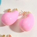 Macro shot of glossy pink teardrop enamel earrings with polished gold metal backings - Pink