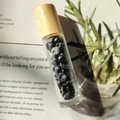 Glass essential oil roller bottle with natural black crystals and light wooden cap - Snowflake Obsidian
