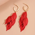 Dettaglio di orecchini a petalo rossi con ganci dorati su sfondo beige minimalista - Perno per orecchini in argento - Rosso