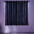 Detail view of white LED curtain lights hanging against black drapes for home decoration - 3x2m Copper Wire Battery Box / White