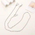 Close-up of polished silver metal bag chain featuring heart-shaped lobster clasps - Silver Flat Chain