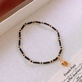 Elegant black beaded bracelet with gold tulip pendant on a decorative card - 3# Bracelet - Black - Conch