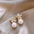 Makroaufnahme eleganter Perlen-Blumenohrringe mit Zirkon-Details auf goldenem Seidenstoff - Gold Blume Strass Perle Ohrstecker (A2230)