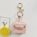 Detailed close-up of pink faux leather mini bag keychain with gold metal hardware and stitching - Lotus Pink