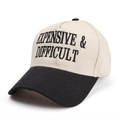 Close-up of 'EXPENSIVE & DIFFICULT' 3D embroidery on a two-tone cotton baseball cap - Adjustable / Black