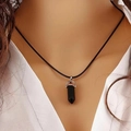 Close-up of a black hexagonal crystal bullet pendant worn on a silver clasp necklace - Obsidian