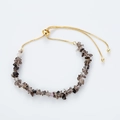 Macro view of smoky quartz irregular beads and golden adjustable drawstring chain - Coffee