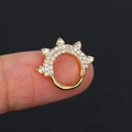 Anello al naso dorato con zirconi e punte mostrato sul dito con macro dettagli - Oro