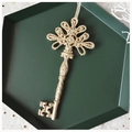 Close-up of golden glitter vintage key ornament on a dark green decorative tray - Key-Champagne Gold