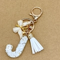 Letter J keychain with gold foil, white petals, butterfly charm, and soft tassel - Letter J