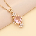 Nahaufnahme der goldenen Halskette mit rosa Edelstein und weißen Zirkonia-Blumen - Rosa