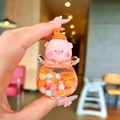 Close-up of pink pig liquid charm keychain with floating beads in orange fluid - Luminous Snowflake Peach Pig - Orange