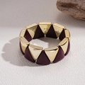 Detaillierte Nahaufnahme von dunkelroten und goldenen Dreieck-Perlen am elastischen Armband - Gold & Dunkelrot