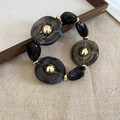 Irregular dark grey resin bead bracelet with gold metal accents on a beige fabric base - Bracelet - Black
