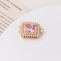 Macro view of gold-plated square clasp with pink gemstone and white zircon setting - Gold-Pink