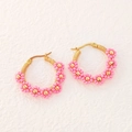 Détail de boucles d'oreilles créoles faites main en perles roses et fil doré chic - Rose
