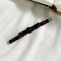 Pinza para el pelo de acetato con textura de carey oscuro sobre tela blanca - Marrón Ámbar
