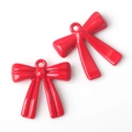 Detail view of two glossy red resin bow pendants for DIY jewelry making accessories - Red