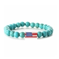 Detail of turquoise beads bracelet with American flag charm on white background - Blue Turquoise Long