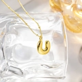 Macro shot of 18K gold plated letter U balloon pendant with polished ball chain - Pendant And Lip Chain / Letter U