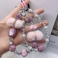 Pink Nepal-style beaded phone strap with fuzzy pom pom and glitter charms - Pink Textured