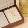 Detailaufnahme eines tropfenförmigen weißen Edelsteins an einer goldenen Kette - 6# Opalit Wassertropfen Stil