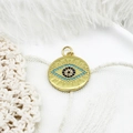 Detailopname van een gouden boze oog hanger met blauwe zirkoon op kant en witte veer - Blauwe Zirkonia Ronde Schijf