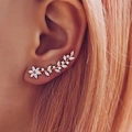 Close-up of rose gold ear crawler with marquise cut zircons in floral leaf design - Gold
