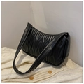 Minimalist black pleated faux leather shoulder bag on a white knitted cardigan - Black