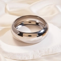 Detail of silver polished thick metal bangle on stone pedestal with satin fabric - Silver Large