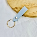 Light blue PU leather keychain with gold metal ring on a wooden display - No.15 Light Blue