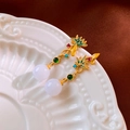 Detail of floral enamel earring with colorful zircons and white pearl on a ceramic plate - Gold Flower Round Bead Drop Earrings