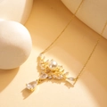Macro detail of gold necklace featuring white pearl and vine-style zircon pendant - XL406 Pearl Deer Horn Gold