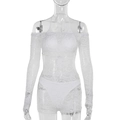 Detail van witte kant jumpsuit met off-shoulder lange mouwen en bloemige haaktextuur - S