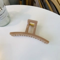 Detalle de una pinza para el pelo caramelo que muestra el resorte metálico dorado - Rosa Nude Profundo