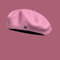 Detail of pink wool beret featuring a classic silver metal logo plate on textured fabric - M / Pink