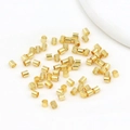 Bulk 18K gold-plated spacer beads for DIY jewelry making scattered on white fabric - 2x2mm / 18k Gold