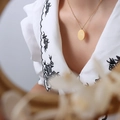 Golden titanium steel necklace with oval flower engraved pendant on a model - November Flower(P1141) / 40cm+5cm / Gold