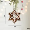 Star-shaped wooden Christmas ornament with snowflake pattern hanging on a pine branch - Snowflake Star