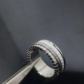 Silver ring with white ceramic inlay and sparkling diamonds held by jewelry tweezers - Style 17