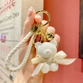 White knitted texture bear keychain with golden bell and woven leather strap - White