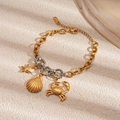 Detailed close-up of mixed-metal marine bracelet with starfish and crab charms - Gold Crab Style